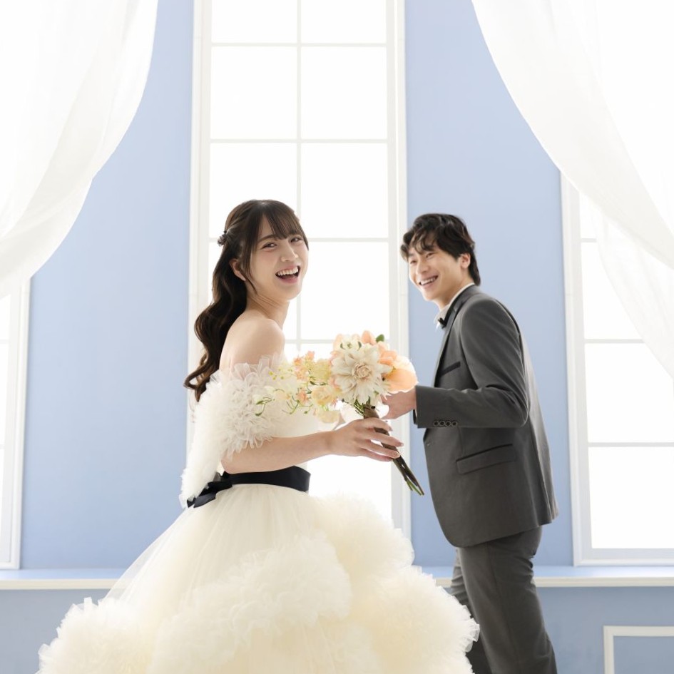 ウェディングフォト。スタジオ撮影をするウェディングドレスを着た新婦とタキシードを着た新郎。