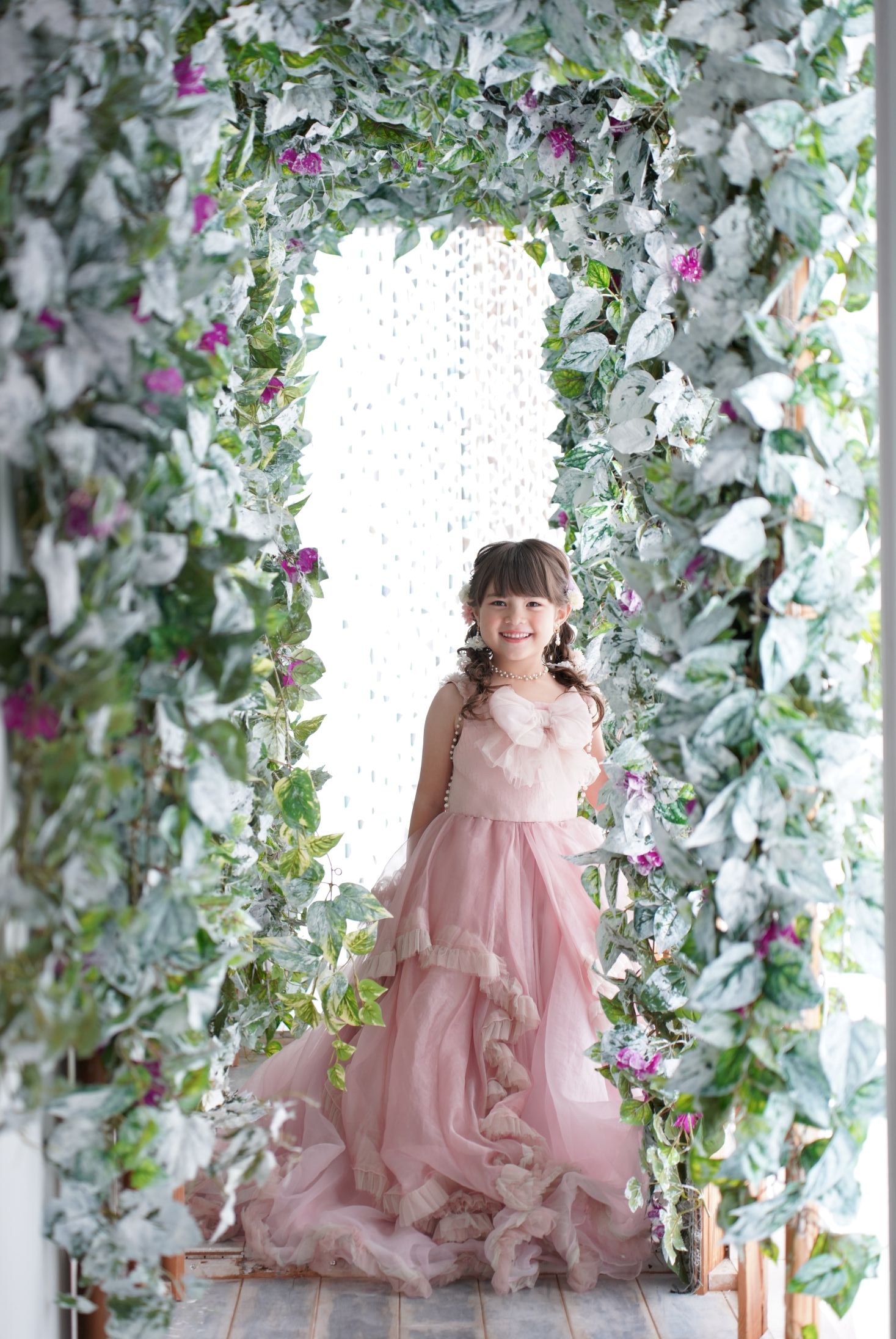 七五三の記念日を迎えた７歳の女の子。オシャレなハウススタジオでドレスを着て笑顔で撮影している写真。テラスモールまつどでの七五三のスタジオ撮影。店舗住所：千葉県松戸市八ヶ崎二丁目8-1 テラスモール松戸3F