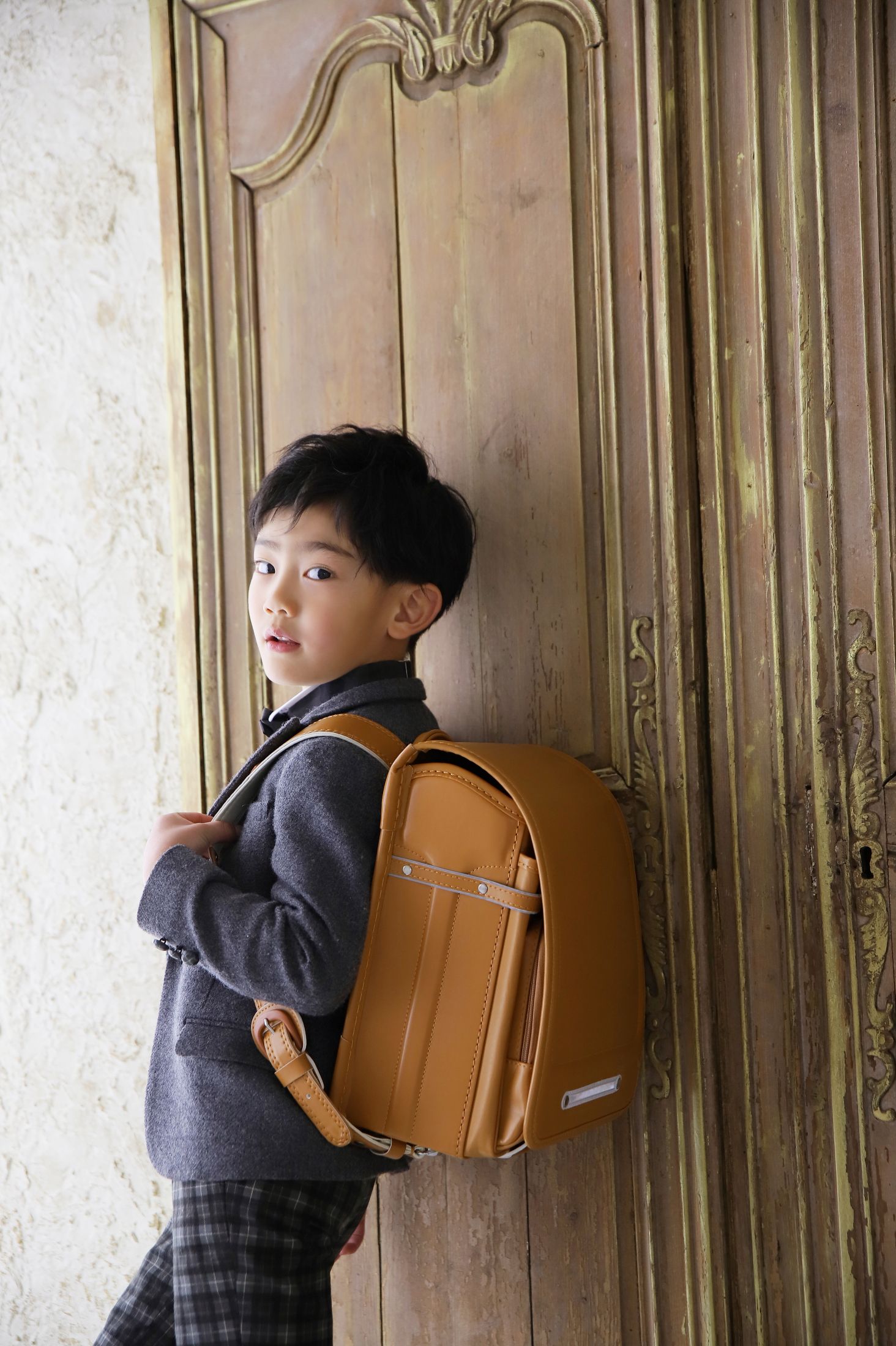 スーツを着てランドセルを背負った6歳の男の子。りんくうシークルでの入学祝いのスタジオ撮影。店舗住所：大阪府泉佐野市りんくう往来南3 りんくうプレジャータウンシークル 1F
