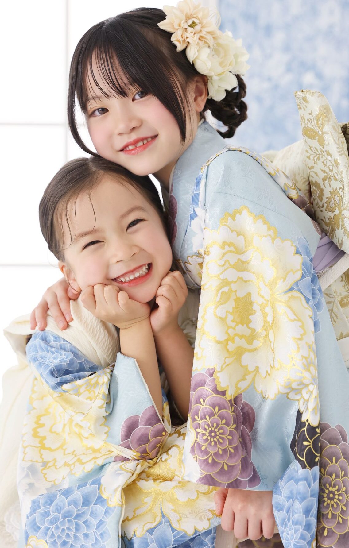 着物を着た3歳の女の子と7歳の姉妹が笑顔で撮影する写真。STUDIOARCでの七五三のスタジオ撮影。