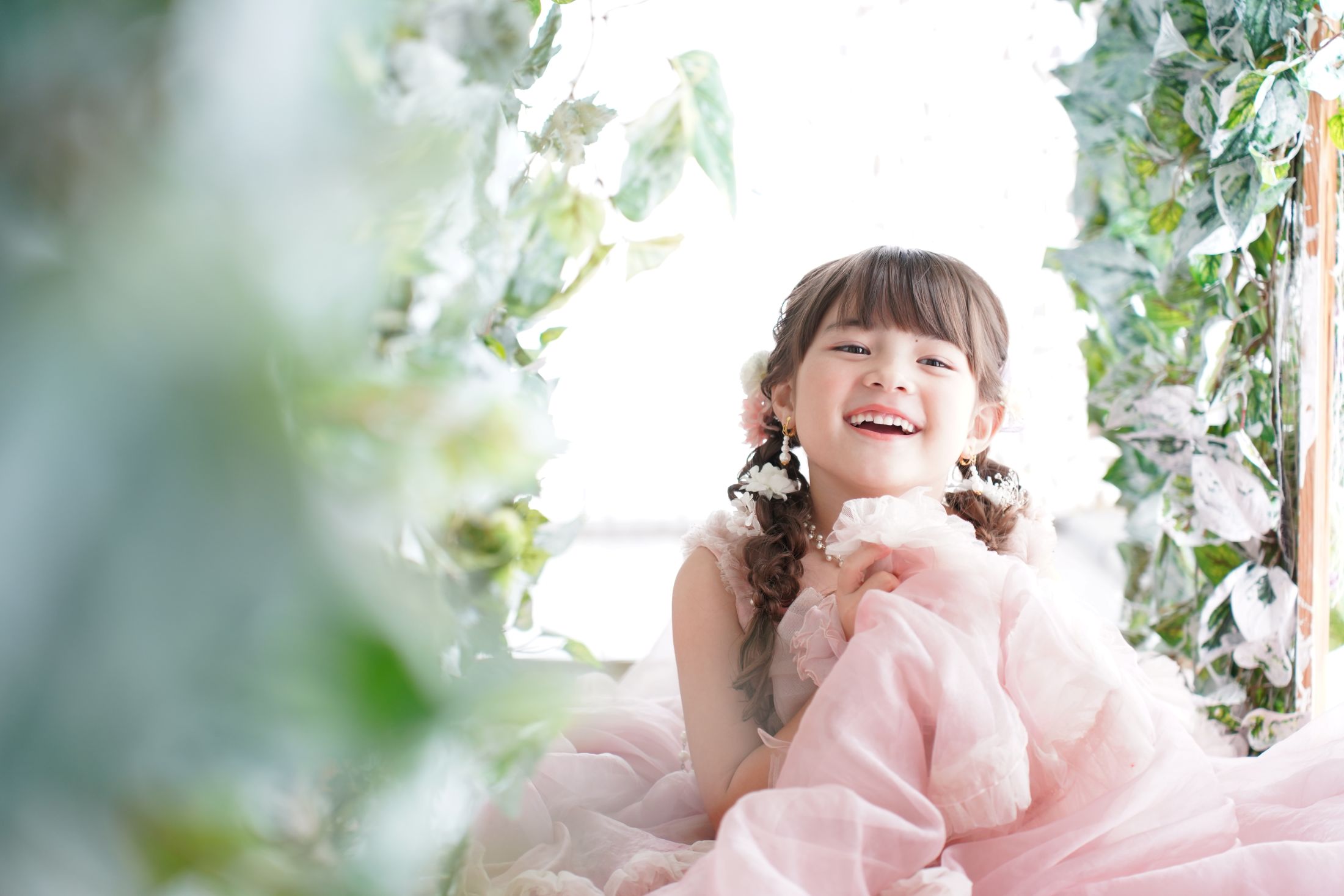 七五三の記念日を迎えた７歳の女の子。オシャレなハウススタジオでドレスを着て笑顔で撮影している写真。テラスモールまつどでの七五三のスタジオ撮影。店舗住所：千葉県松戸市八ヶ崎二丁目8-1 テラスモール松戸3F