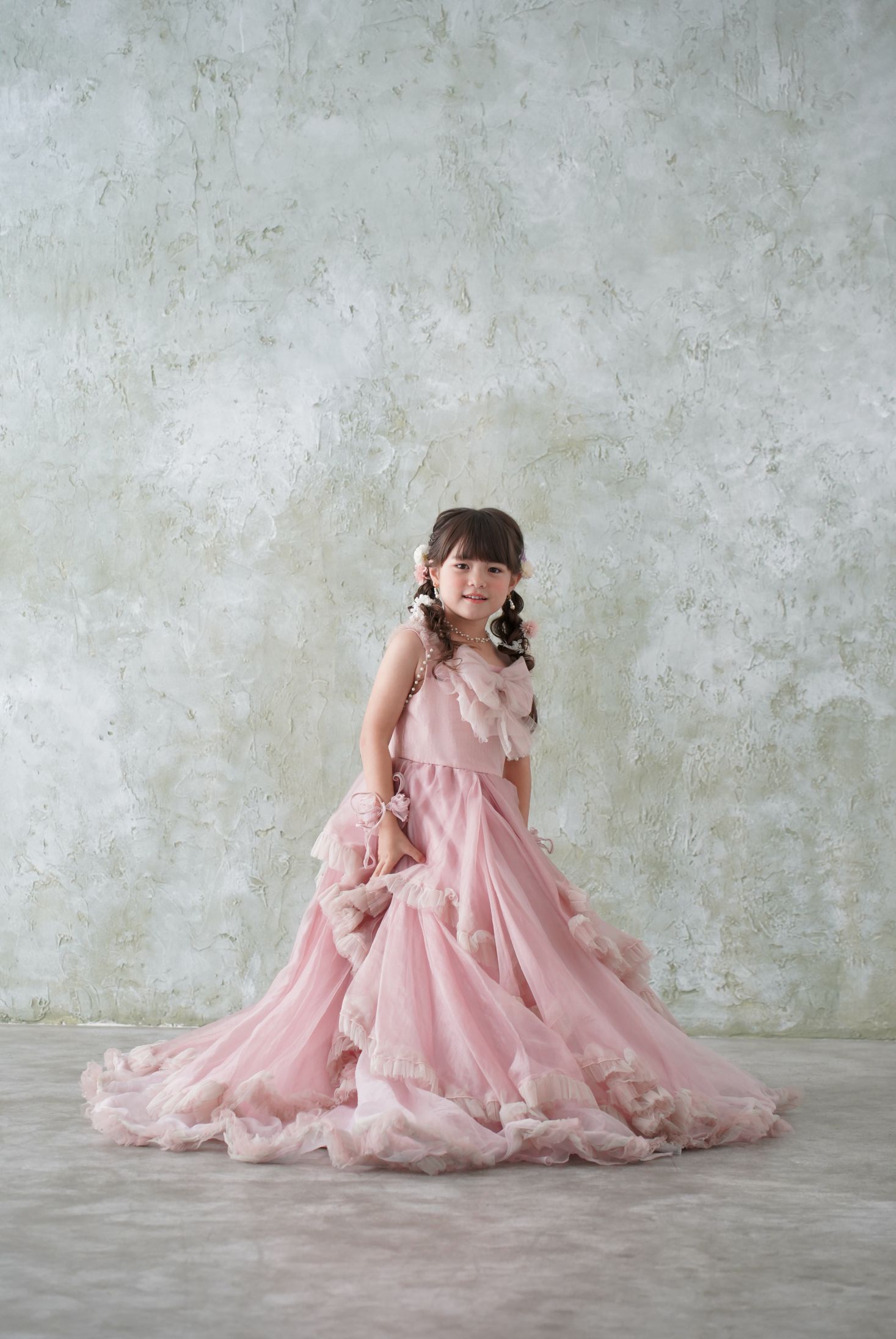 七五三の記念日を迎えた７歳の女の子。オシャレなハウススタジオでドレスを着て笑顔で撮影している写真。テラスモールまつどでの七五三のスタジオ撮影。店舗住所：千葉県松戸市八ヶ崎二丁目8-1 テラスモール松戸3F