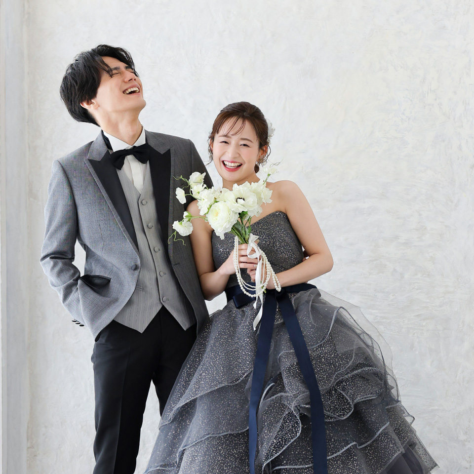 ウェディングカラードレスの新婦とタキシード姿の新郎