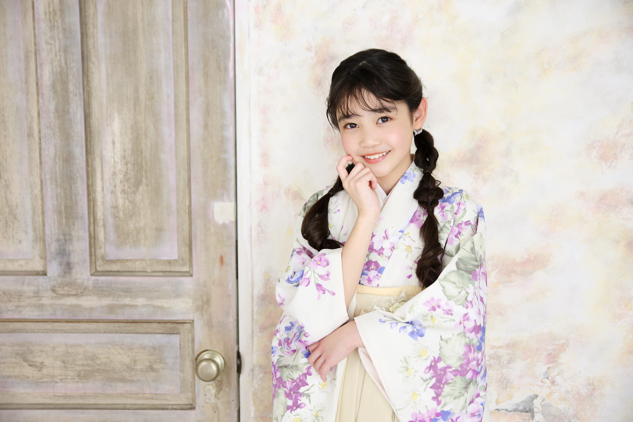 花柄の着物と袴を着て笑顔で立つ女性