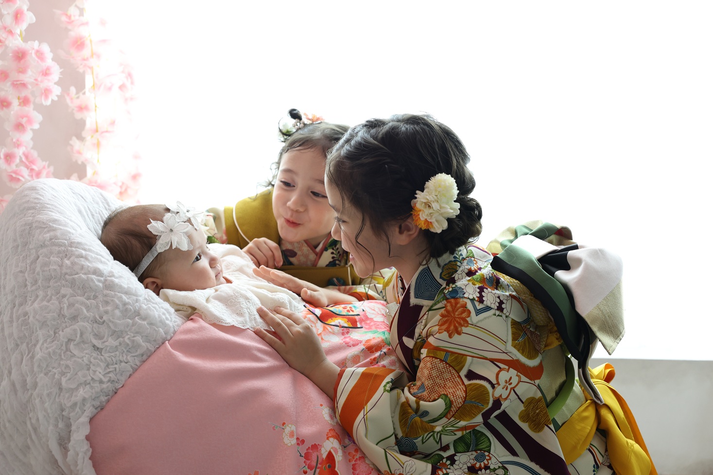 着物姿の三姉妹で撮影したお宮参り記念写真。お姉ちゃんたちの優しさがあふれるショット。