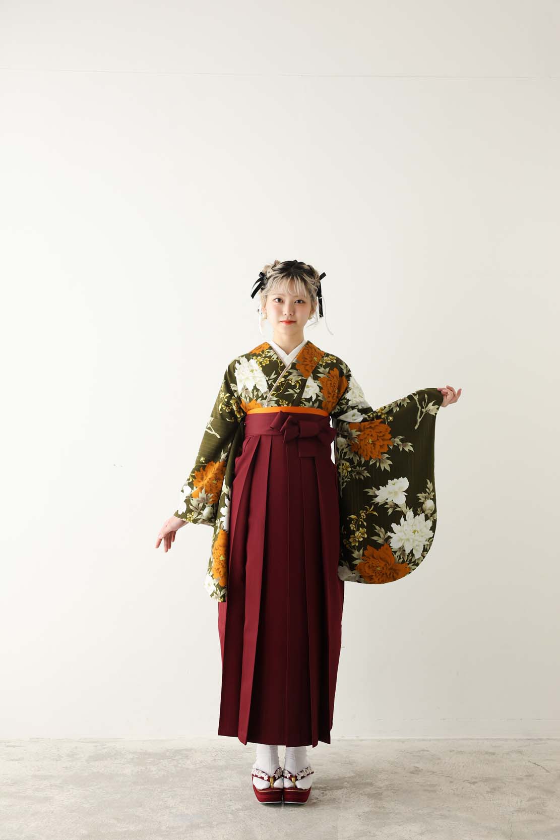 深緑地に白とオレンジの花柄着物とえんじ色の袴を合わせた卒業袴コーディネート