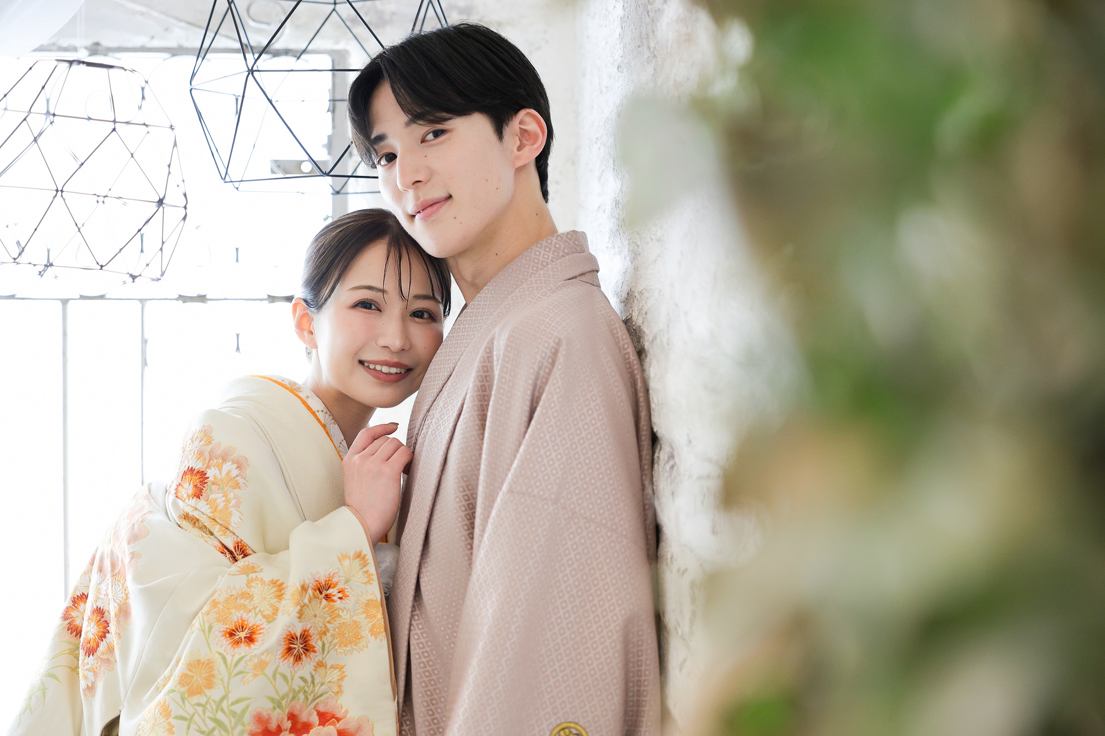 色打掛と袴でフォトウェディングの撮影をする新郎新婦様。柔らかな光と、天井から吊るされたアンティーク調なアイアンの飾りを背景に撮影をしている写真。撮影店舗：しんかな大阪南店 住所：大阪府堺市北区長曽根町3069-7