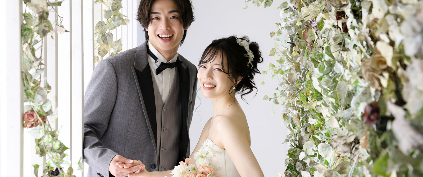 ウェディングサイト_トップ写真_スタジオ撮影をするウェディングドレスの新婦とタキシードの新郎
