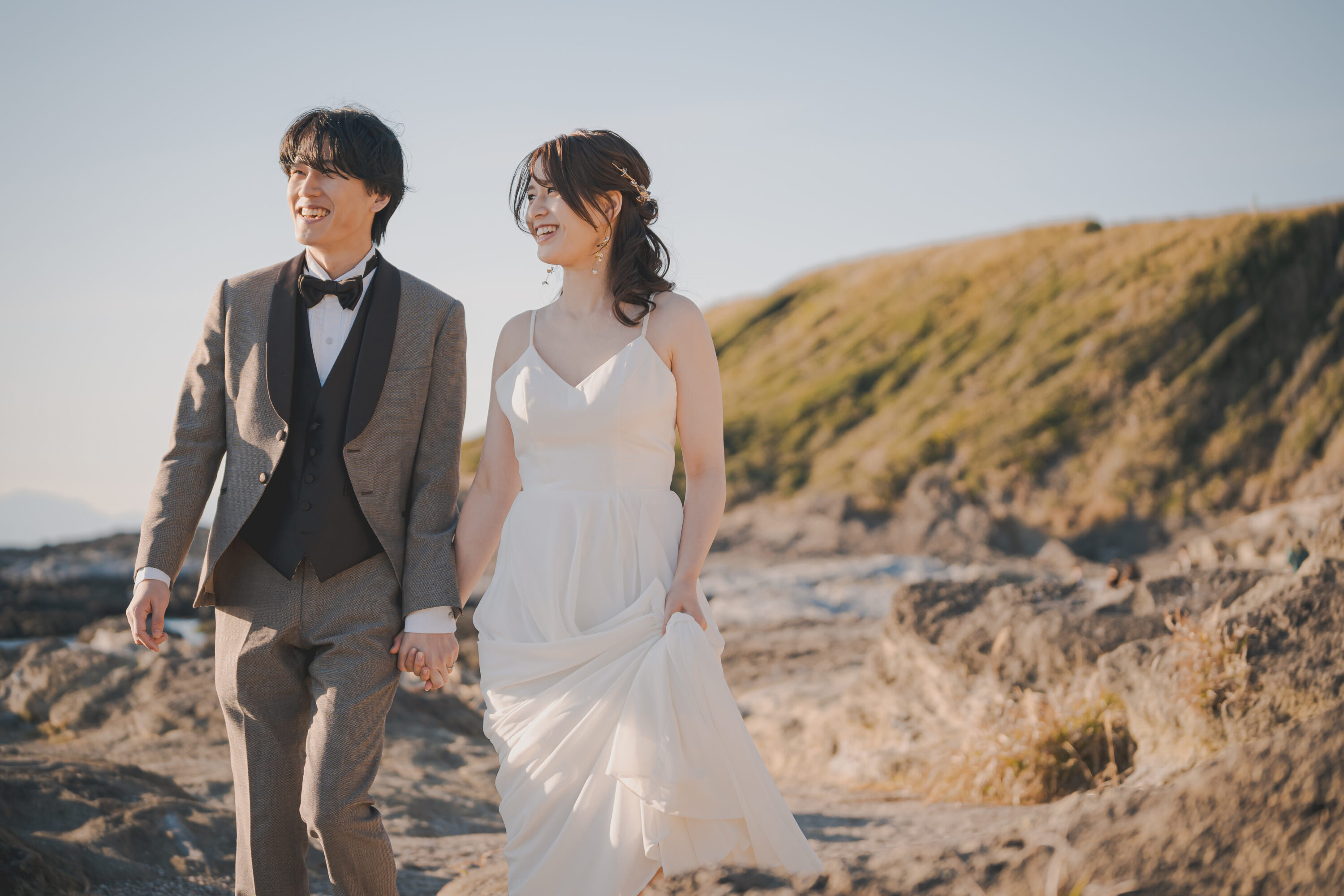 城ケ島でフォトウェディングの撮影をしている新郎新婦様の写真。白のウェディングドレスとタキシードが青空に映える人気のロケーション地。撮影：STUDIOARC