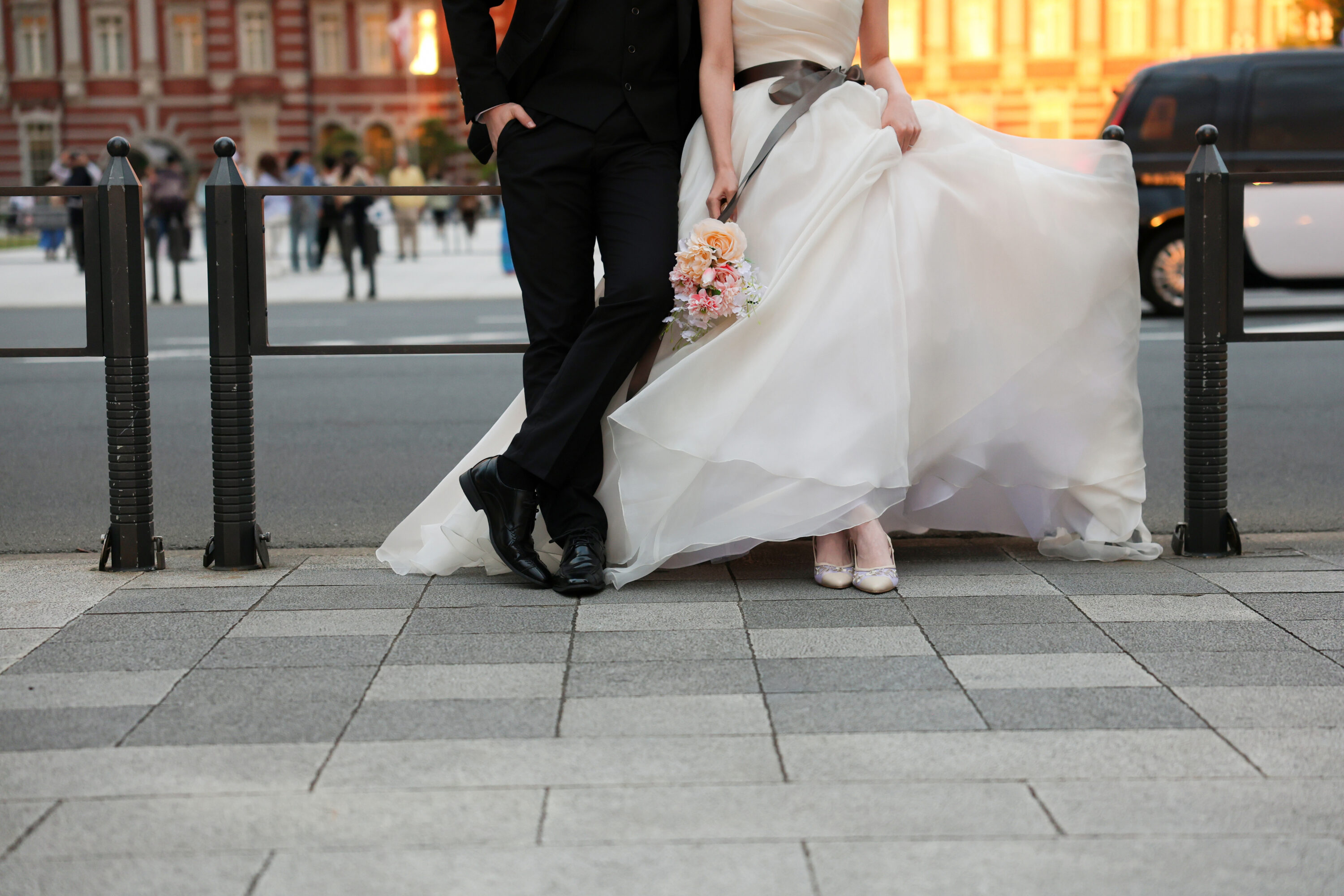 東京駅でウェディングドレスとタキシードを着てフォトウェディングの撮影をする新郎様と新婦様の写真。撮影：STUDIOARC