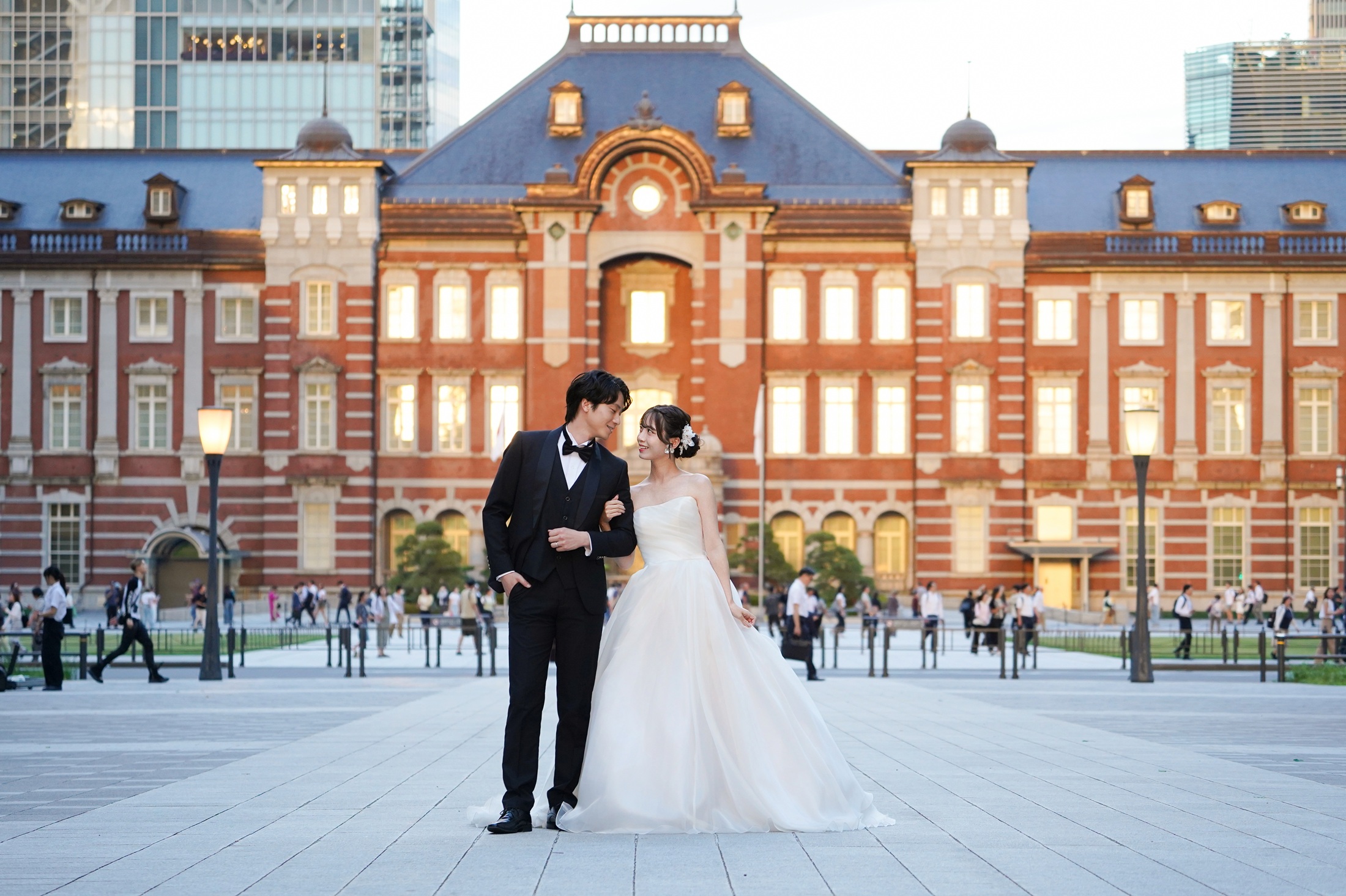 東京駅でウェディングドレスとタキシードを着てフォトウェディングの撮影をする新郎様と新婦様の写真。撮影：STUDIOARC