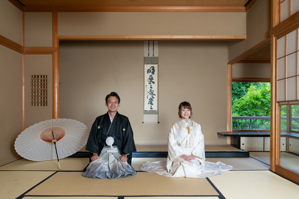 目白庭園でフォトウェディングの撮影をする袴を着た新郎様と打掛を着た新婦様。和室の中で和装を着て撮影をしている写真。撮影：STUDIOARC