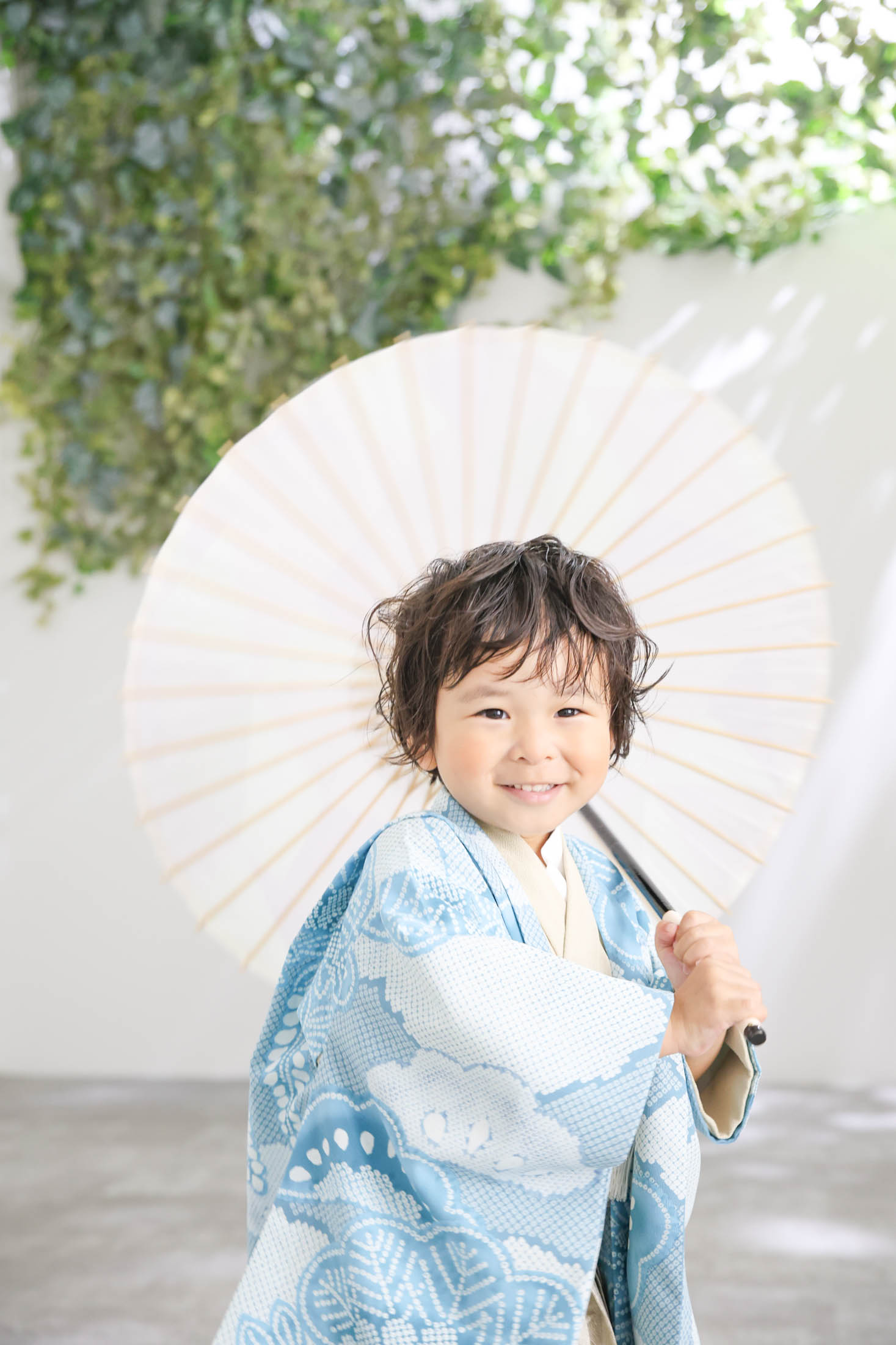 STUDIOARCららぽーと安城店で古典柄の着物を着て七五三の写真を和傘を持って笑顔で撮影する３歳男の子。 撮影店舗住所：愛知県安城市大東町9番30号 ららぽーと安城 1F