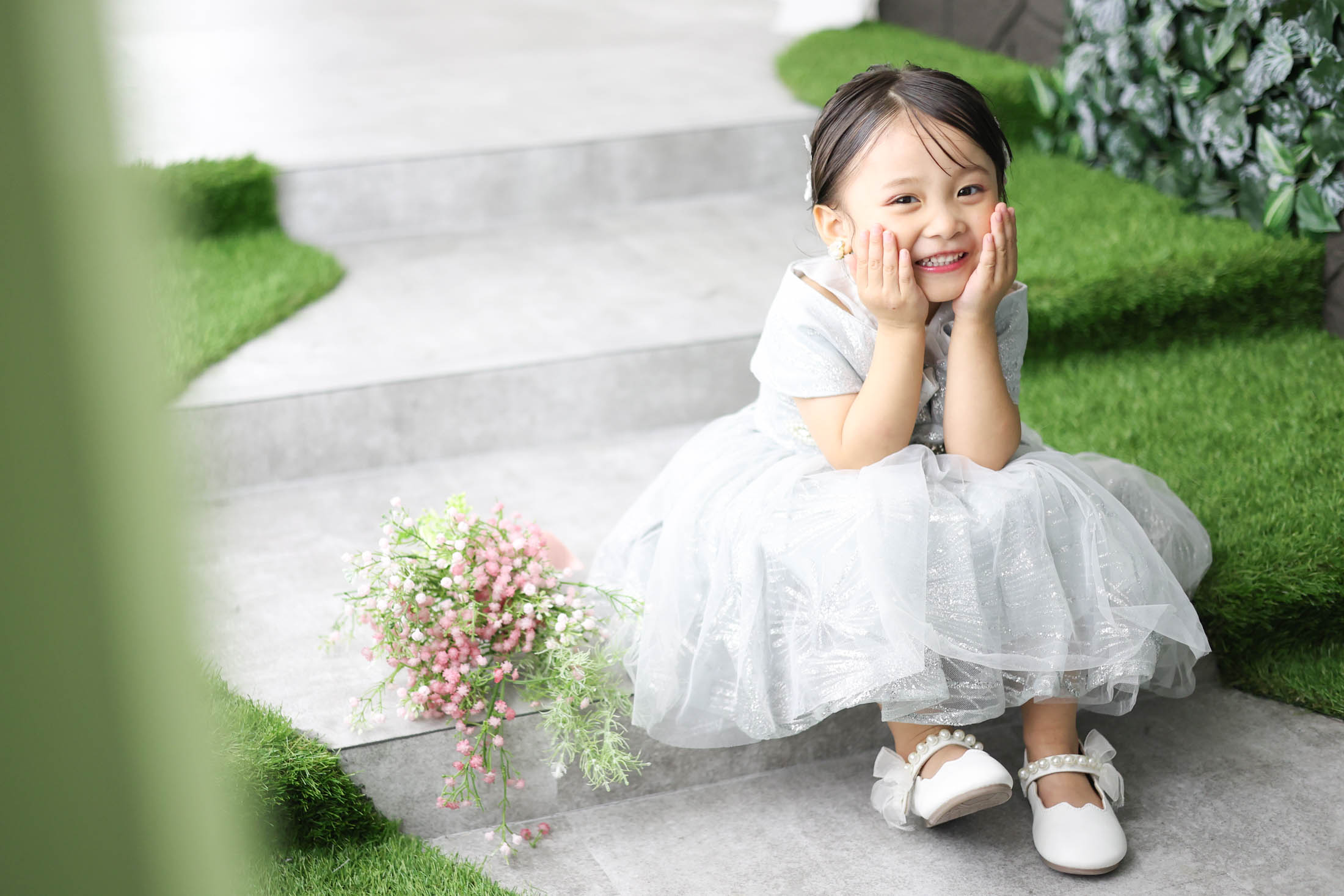 STUDIOARCららぽーと安城店で白色のドレスを着て七五三の写真を笑顔で撮影する３歳女の子。 撮影店舗住所：愛知県安城市大東町9番30号 ららぽーと安城 1F