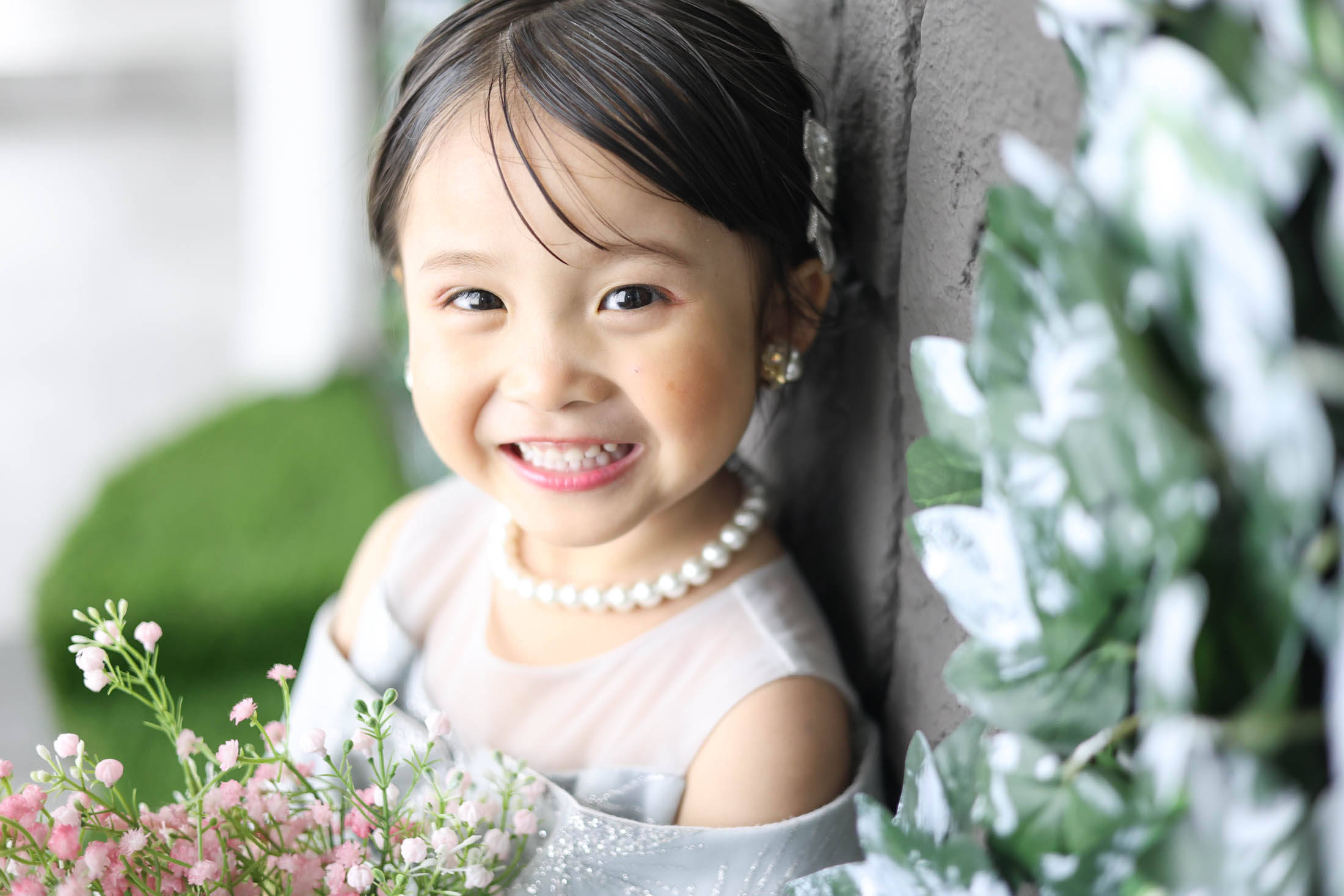 STUDIOARCららぽーと安城店で白色のドレスを着て七五三の写真を笑顔で撮影する３歳女の子。 撮影店舗住所：愛知県安城市大東町9番30号 ららぽーと安城 1F
