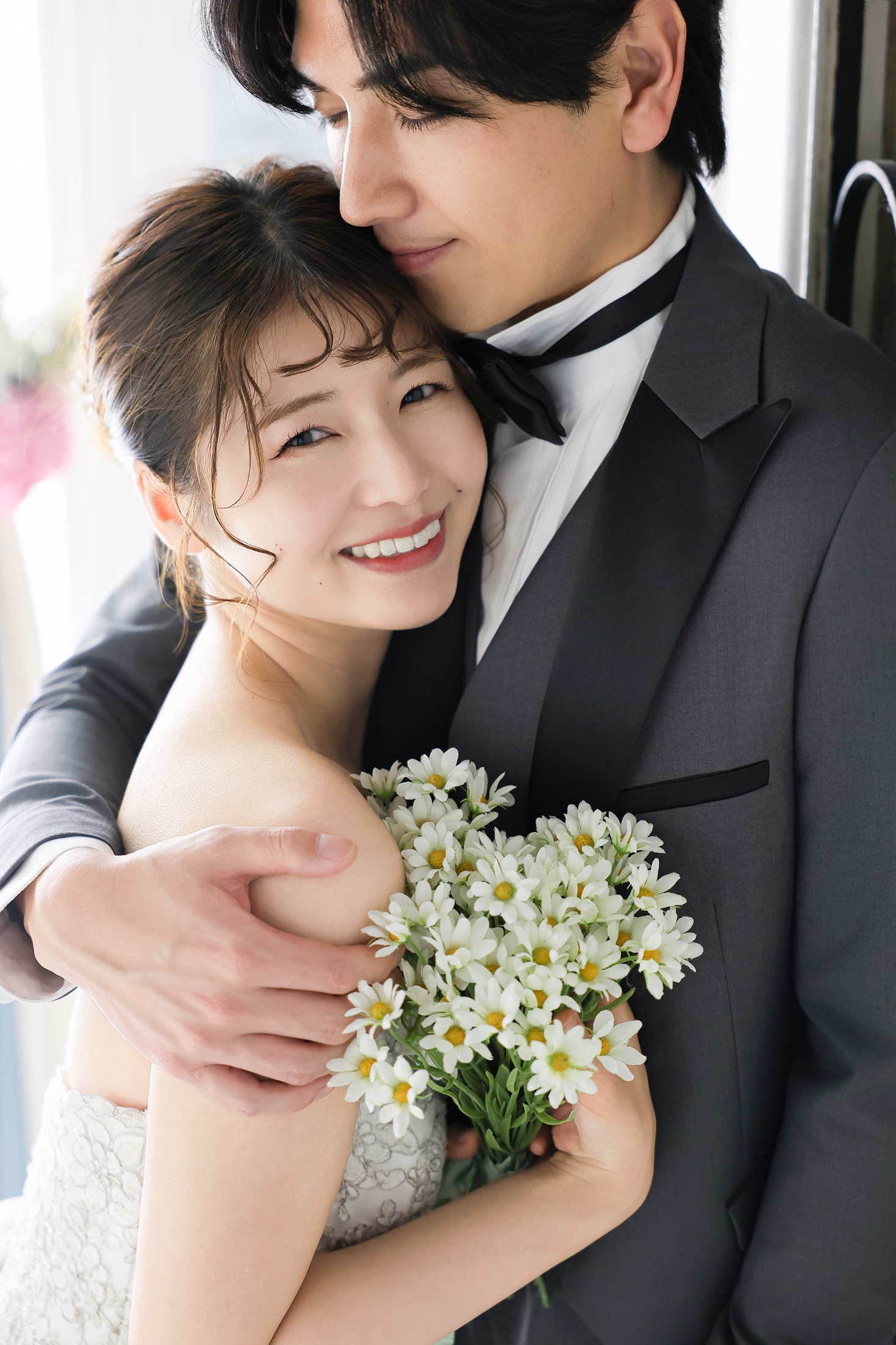 ウェディングドレスとタキシードでフォトウェディングの撮影をする新郎新婦様。ナチュラルなブーケを抱えた新婦様と新郎様が寄り添うアップ写真。撮影店舗：神戸ハーバーランド店 住所：兵庫県神戸市中央区東川崎町1-5-5 ハーバーランド煉瓦倉庫