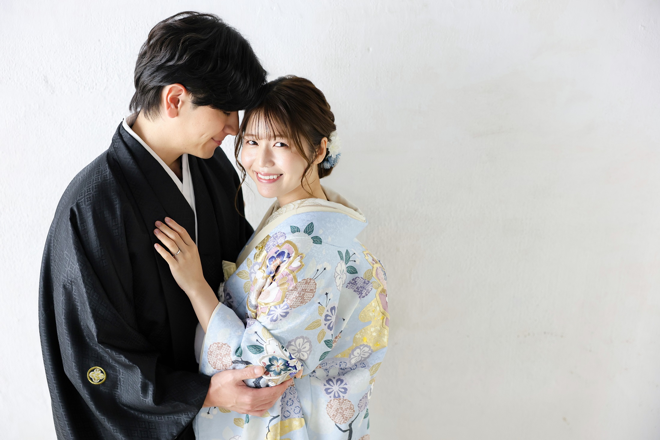 色打掛と袴でフォトウェディングの撮影をする新郎新婦様。真っ白な壁を背景に、水色の色打掛が映える新婦様と新郎様を撮影した写真。撮影店舗：神戸ハーバーランド店 住所：兵庫県神戸市中央区東川崎町1-5-5 ハーバーランド煉瓦倉庫