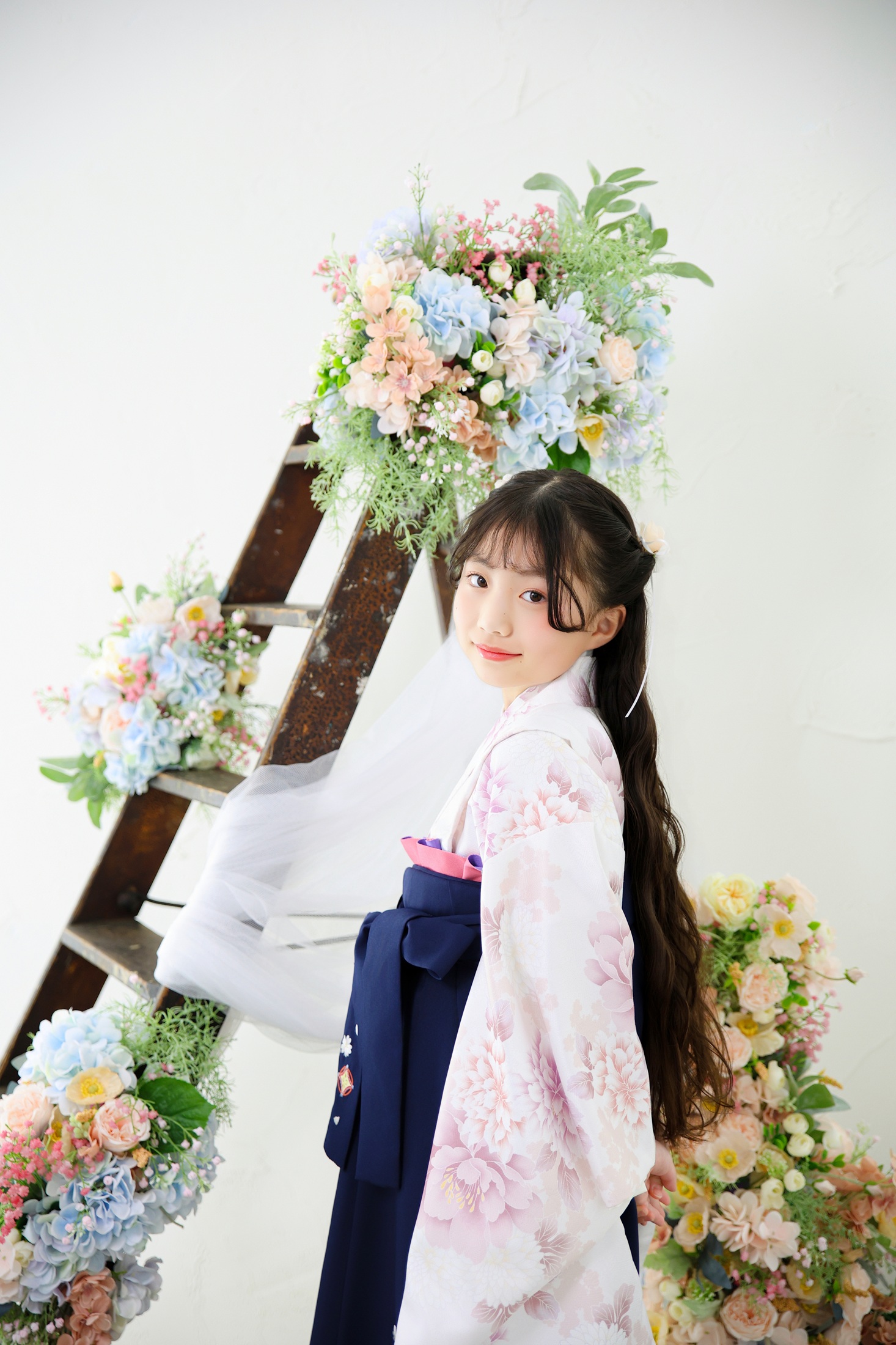 小学校の卒業記念で袴を着て撮影している１０歳の女の子。お花の背景がナチュラルで人気。撮影店舗：STUDIOARCららぽーと安城店／愛知県安城市大東町9番30号 ららぽーと安城 1F