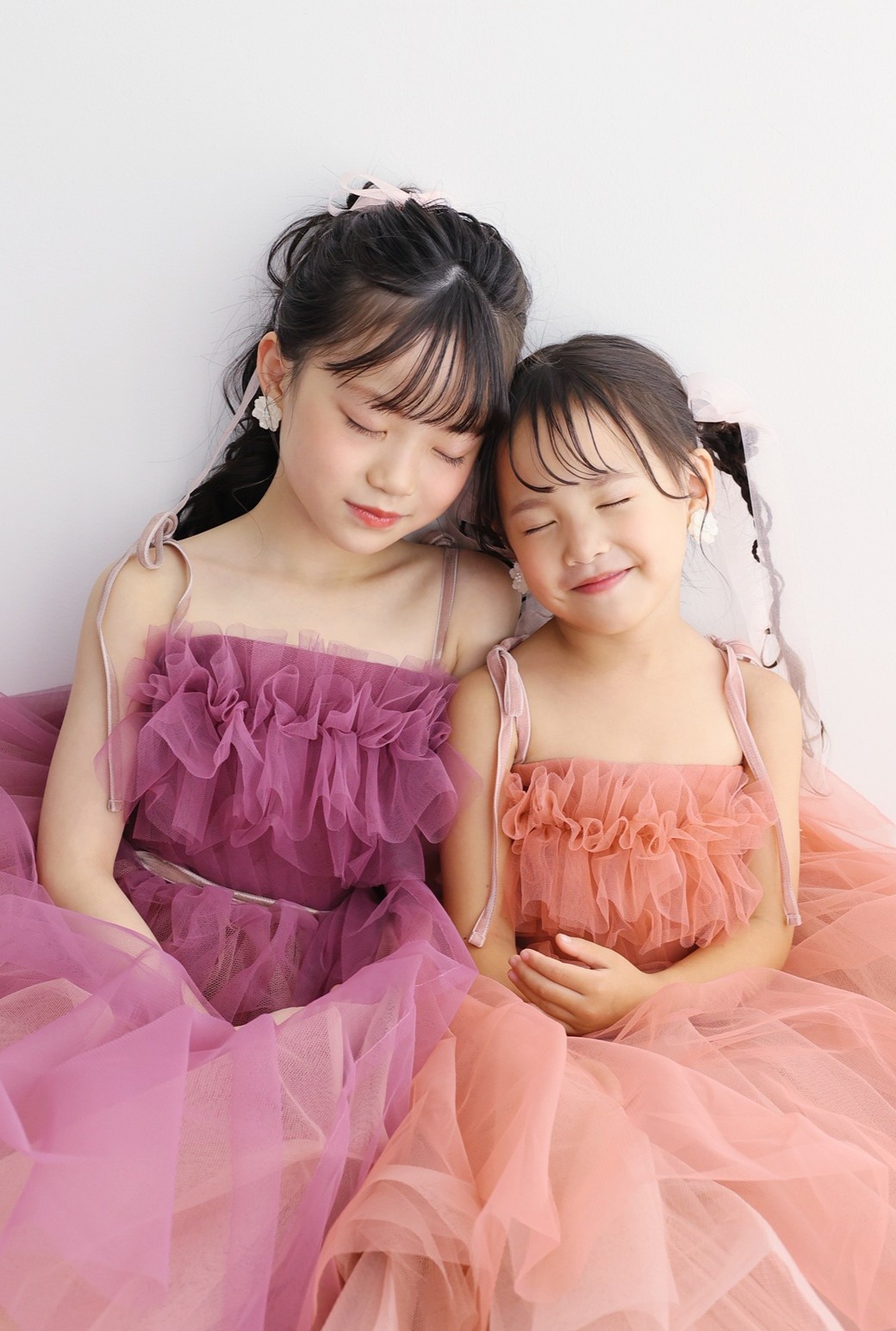 七五三の撮影でSTUDIOARCオリジナルのお揃いのドレスを着て撮影する３歳と７歳の姉妹。トレンドのナチュラルカラーのドレスが人気。掲載店舗：STUDIOARCららぽーと安城店／愛知県安城市大東町9番30号 ららぽーと安城 1F