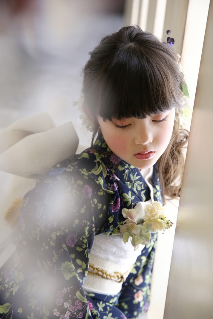 ボタニカル柄の着物を着て髪飾りをつけた七五三の女の子の写真