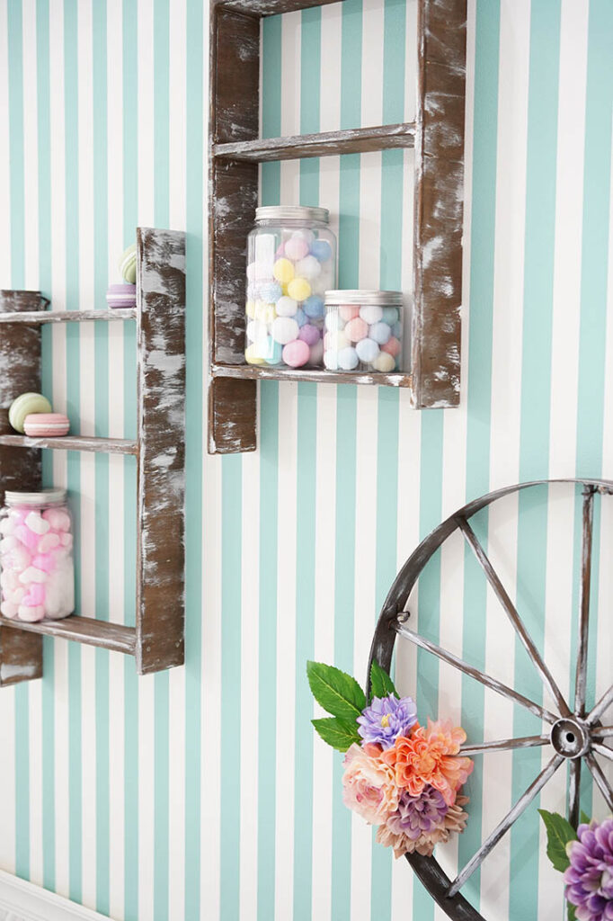 STUDIO ARCの限定背景「スイ~ツ♡ループ」でミントグリーンのストライプ壁に飾り棚やお菓子瓶、お花を飾ったインテリアのアップ画像。