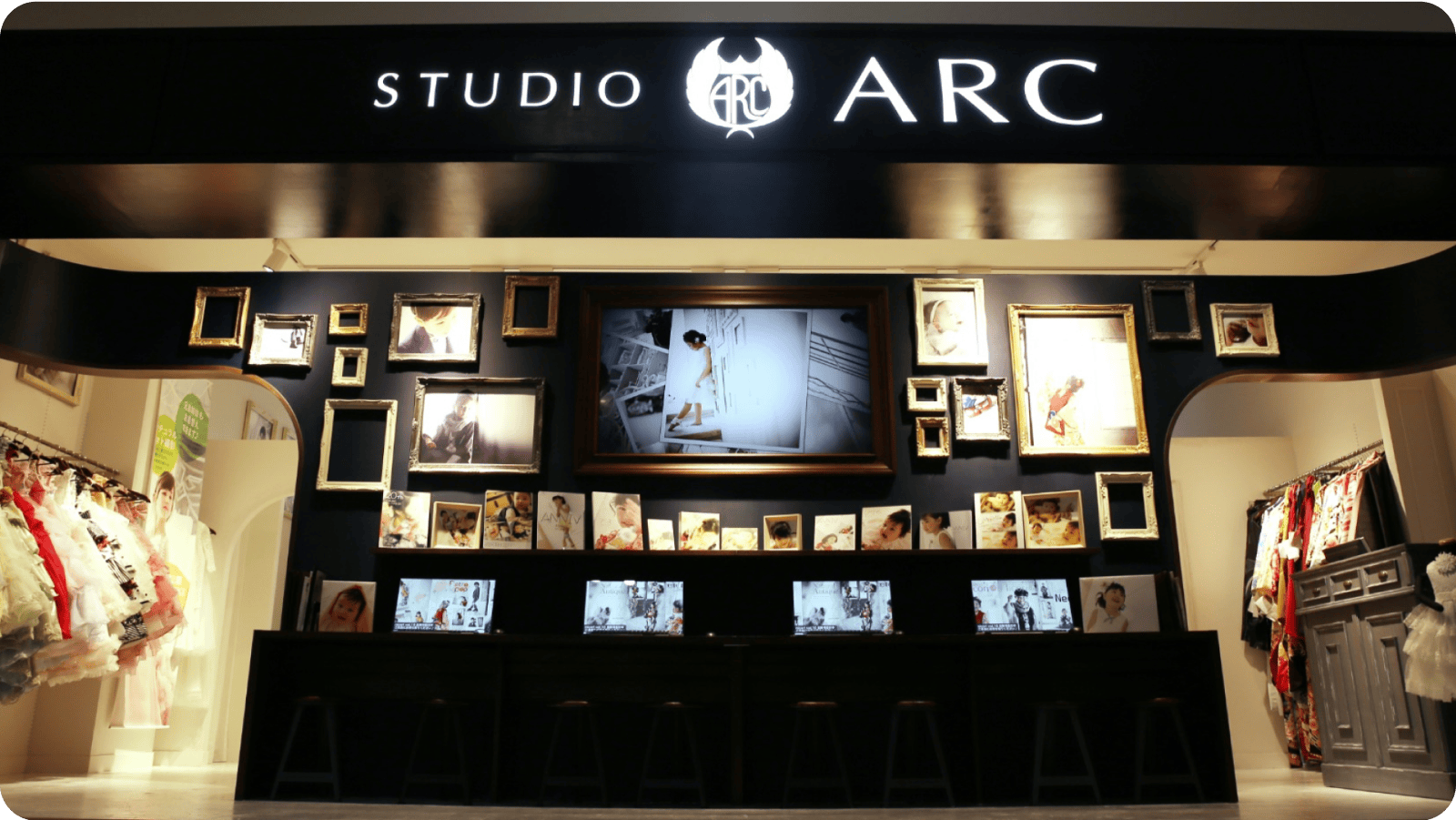 「STUDIO ARC」のロゴが掲げられた店舗の外観。たくさんの額縁や写真が飾られたディスプレイと衣装が並ぶスタジオのエントランス