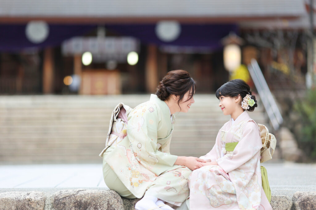 七五三撮影でお母さんと一緒に笑顔で写る子どもの記念写真