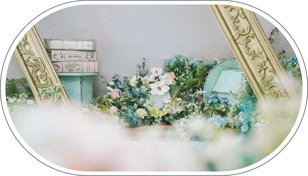 スタジオアーク芝Parkside STUDIO店のディスプレイ、ゴールドフレームの鏡と白やブルーの花のアレンジメント