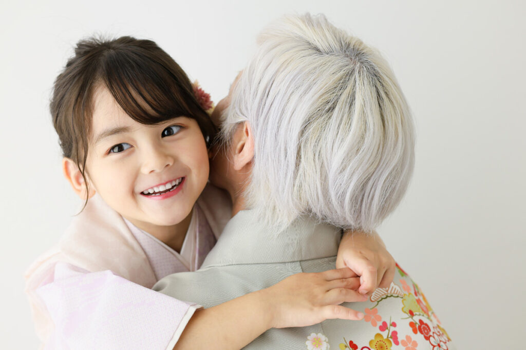 祖母と孫が着物姿で寄り添う七五三の記念写真