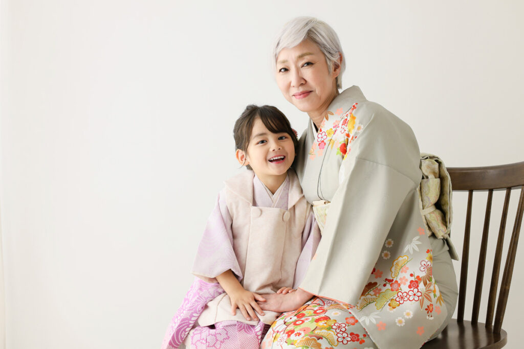 祖母と孫が着物姿で寄り添う七五三の記念写真