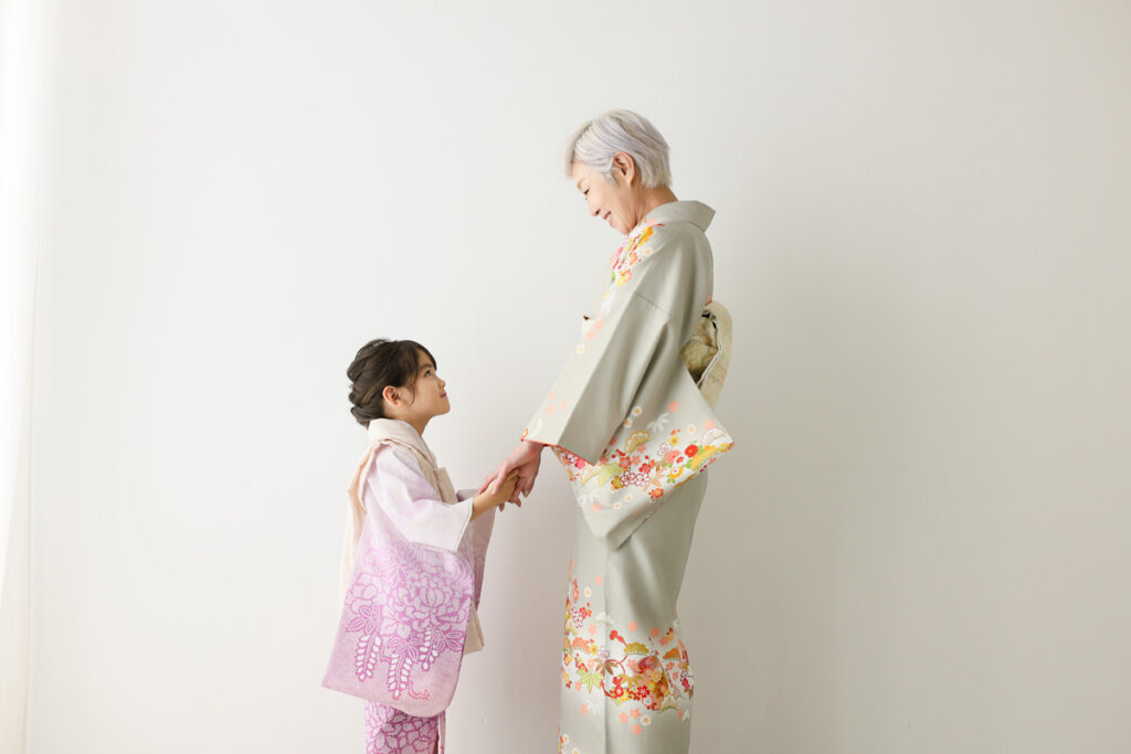 祖母と孫が着物姿で寄り添う七五三の記念写真