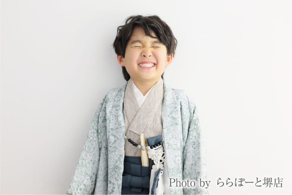 七五三の袴姿で目をぎゅっとつぶってくしゃっと笑う男の子|ららぽーと堺店のスタジオ撮影
