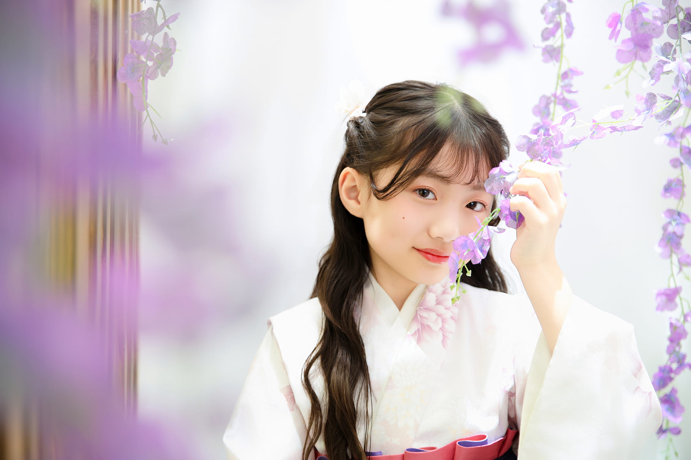 紫色の花に囲まれた女の子の卒業袴姿