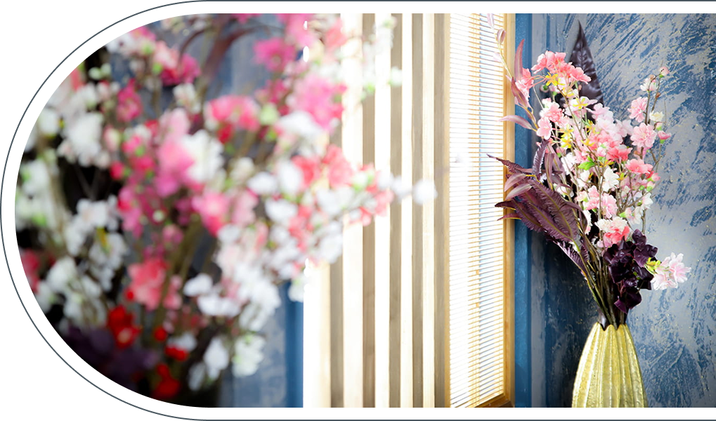 スタジオアークイオンモール堺鉄砲町店のディスプレイ、ピンクや白の花を生けた花瓶とブルーの壁