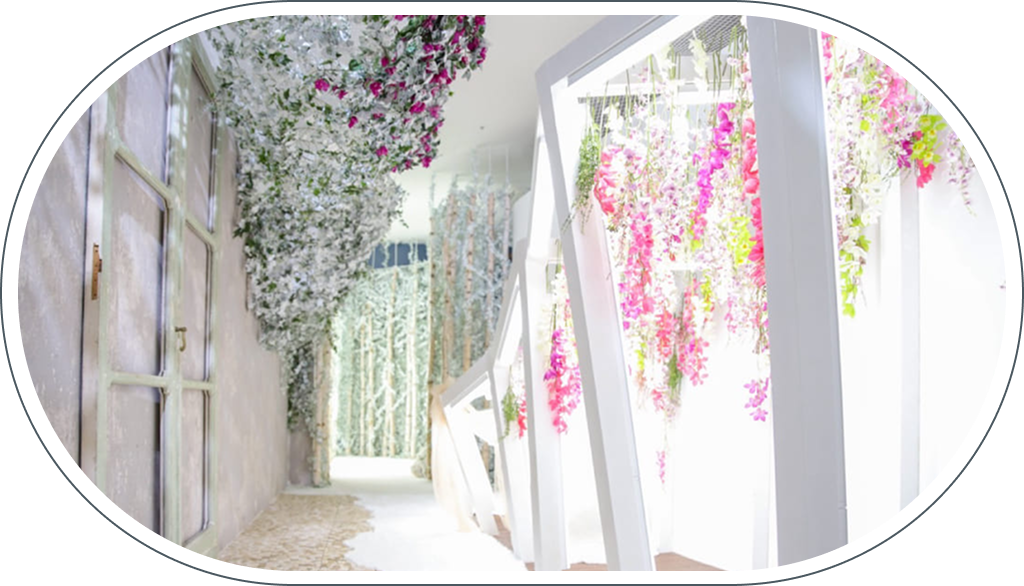 ららぽーと堺店のディスプレイ、ピンクや白の花が垂れ下がる通路と奥に広がる白樺の森