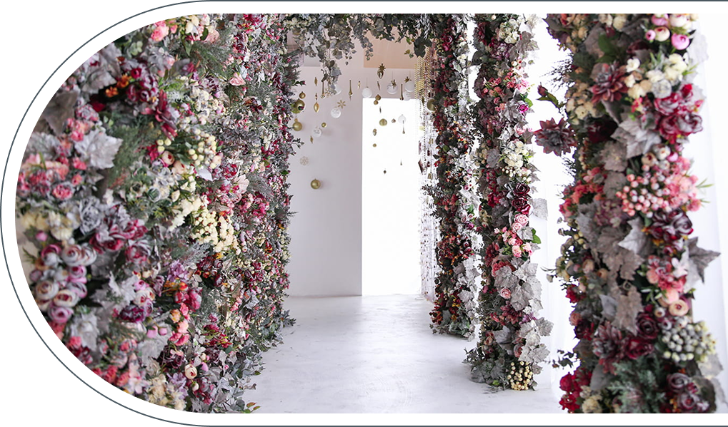 りんくうシークル店のディスプレイ、赤やピンクの花で覆われた柱が並ぶ通路と奥にオーナメントの装飾