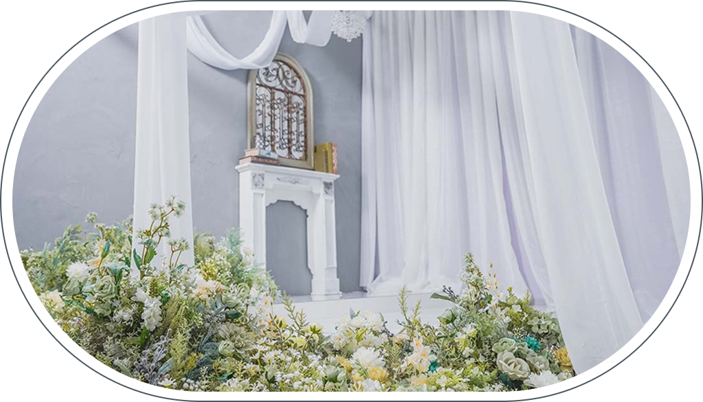 スタジオアークららテラスHARUMI FLAG店のディスプレイ、白い暖炉とシアーカーテン、白緑の花のアーチ