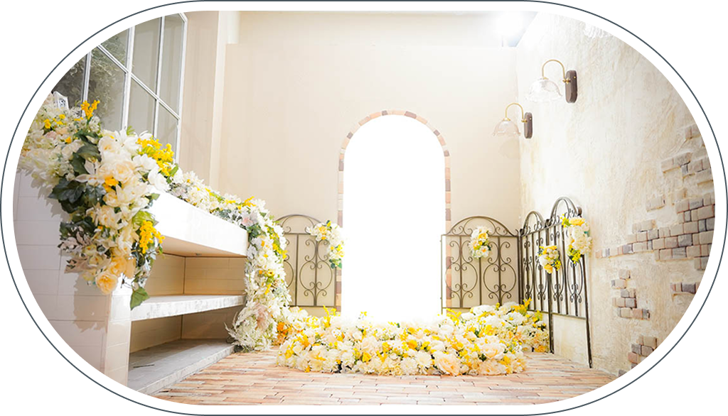 スタジオアークセンター北店のディスプレイ、黄色と白の花で飾られたアーチとアイアンフェンス