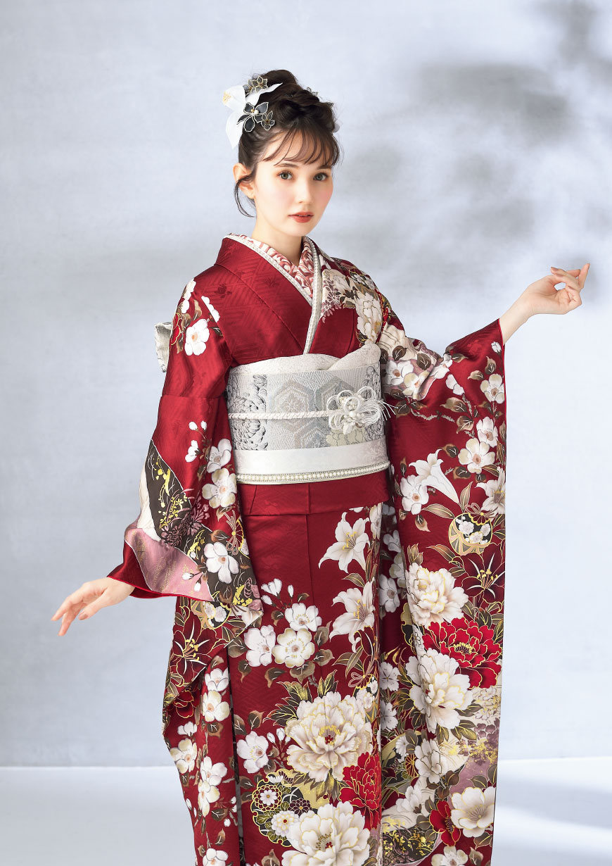 Coffret ワインレッドの地に紅白の牡丹や百合が描かれた振袖に白銀の菊柄袋帯を合わせたコーディネート