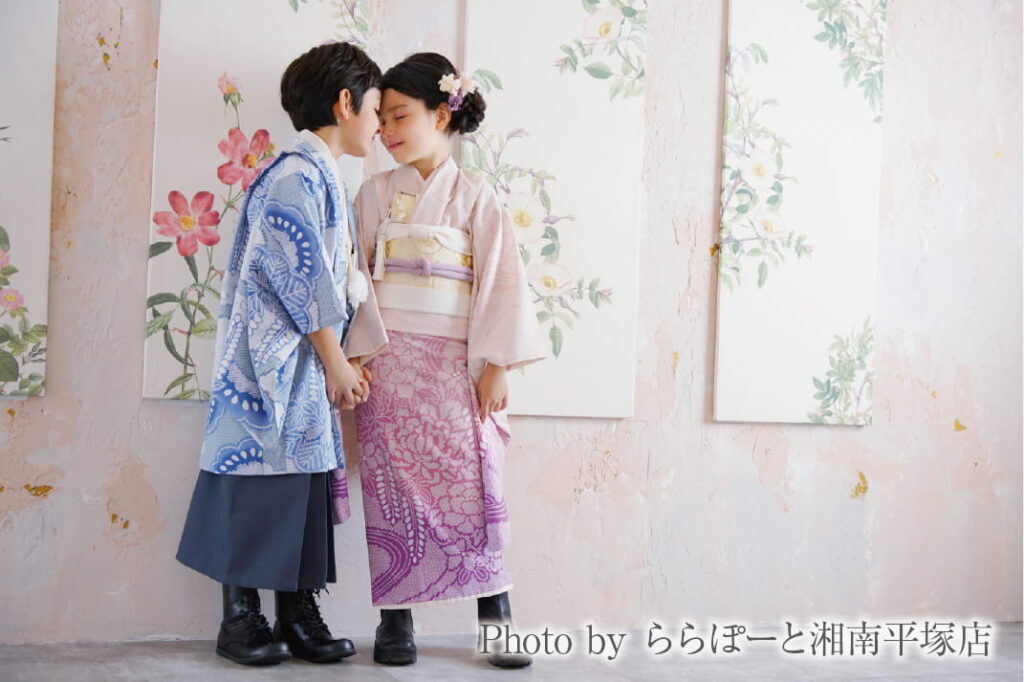 青い羽織袴の男の子とピンクの着物の女の子がおでこを寄せて手をつなぐ写真|ららぽーと湘南平塚店で撮影