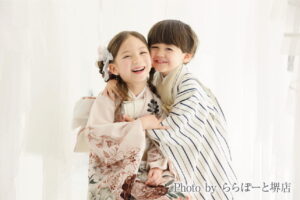 七五三は兄弟・姉妹で撮影|メリット・撮り方とお参りの準備 着物姿の女の子と羽織袴の男の子がほっぺを寄せて抱き合い笑う写真|ららぽーと堺店で撮影