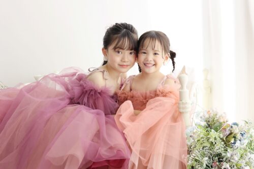 ドレスを着た10歳の女の子と5歳の女の子。姉妹。ららぽーと堺での七五三の1/2成人式のスタジオ撮影。