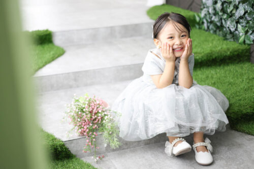 STUDIOARCららぽーと安城店で白色のドレスを着て七五三の写真を笑顔で撮影する３歳女の子。 撮影店舗住所：愛知県安城市大東町9番30号 ららぽーと安城 1F